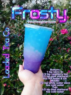 a hand holding up a purple and blue drink in front of some pink flowers with the words frosty on it