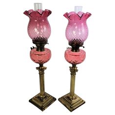 two pink glass vases sitting on top of each other in front of a white background