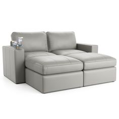 a grey couch with two recliners sitting on it's back and one end facing