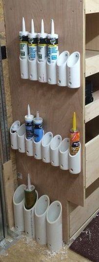 there are many cups on the wall with toothbrushes and glues in them