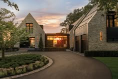 the sun is setting in front of a house with stone walls and windows on each side