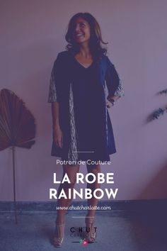 a woman standing in front of a wall with the words la robe rainbow on it