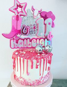 a birthday cake with pink icing and decorations