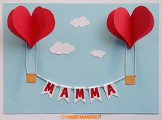 two red paper hearts hanging from clothes pins with the word mama spelled in front of them