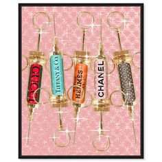 three wine corks with the words chanel hanging from them on a pink background