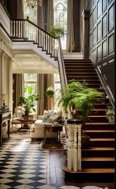 a staircase in a large house with potted plants on the top and bottom floor