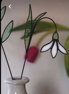 a white vase with some flowers in it