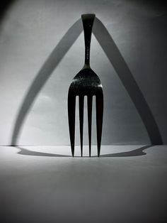 a fork casting a shadow on the wall