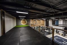 an indoor gym area with exercise equipment on the wall and green carpeted flooring