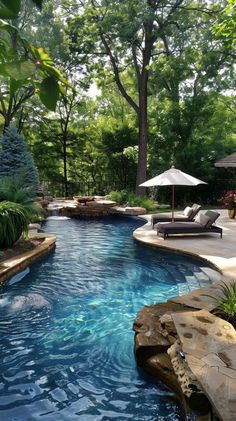 an outdoor swimming pool surrounded by trees and rocks