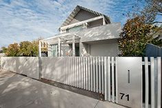 a white fence is in front of a house