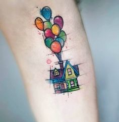 a house with balloons tattoo on the side of its leg and it's legs