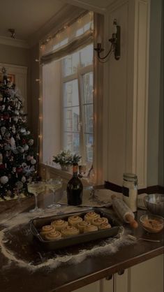 a christmas tree is in the background with cookies on a tray and other items around it