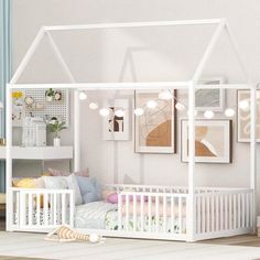 a child's room with a white bed and some pictures on the wall