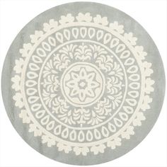 a round rug with an intricate design on the center and bottom in grey, white and beige