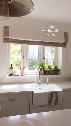 a kitchen sink under a window next to a dishwasher and cabinets with windows