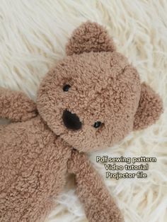 a brown teddy bear laying on top of a white fur covered floor with the caption