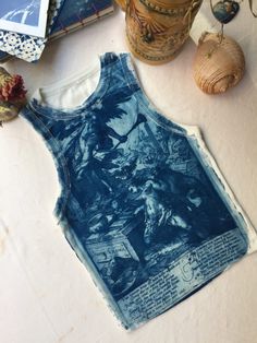 Item Overview: *Handmade item *Cyanotype print *Shipping from Turkey, Istanbul Item Details *%95 cotton, %5 elastane S 28x36 cm M 29x37 cm L 31x39 cm What is Cyanotype? Cyanotype is a one of the oldest photographic printing process that produces blue print using the sun! We use hight-quality fabrics and papers to make the prints. First, we coat the surface with a light-sensitive emulsion and then expose it to in direct sunlight. Any part of the surface that is exposed will react and change color. Finally we rinse it in water and stabilize the print. Most beautiful part of the process is every item is unique. Care: Detergents includes posphates can damage the print and the prints color may fade or discolor. Hand washing in cold water with non-phosphate detergent is recommended. Do not bleac Fitted Cotton Tops With Printing, Solar Printing, Cyanotype On Jeans, Cyanotype Printing On Clothes, Cyanotype Print, Sun Printing, Cyanotype Shirts, Sun Printing On Fabric, Cyanotype On Fabric