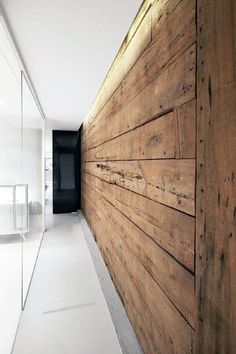 an empty hallway with wooden walls and white floors