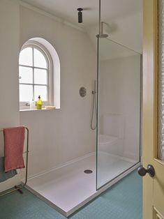 a bathroom with a walk in shower next to a window