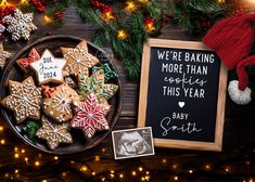 christmas cookies are on a plate next to a chalkboard