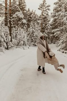 a woman is standing in the middle of a snowy road with her legs spread out