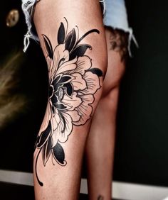 a woman's leg with flowers on it and tattoos on the side of her legs