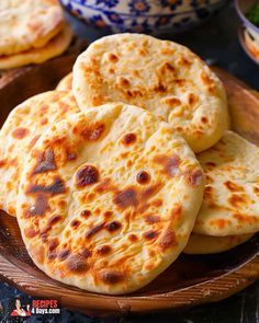 several flat breads on a wooden plate