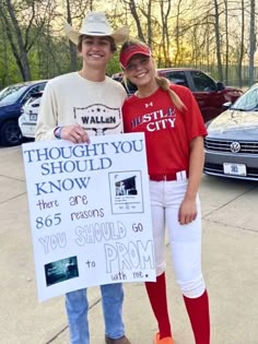 two people standing next to each other holding a sign