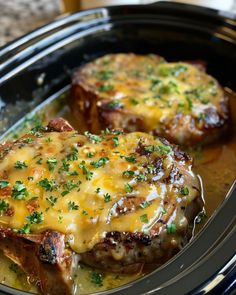 two steaks covered in gravy and garnished with parsley