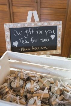 a box filled with lots of tea bags and a chalkboard sign above it that says our gift for you tea for two