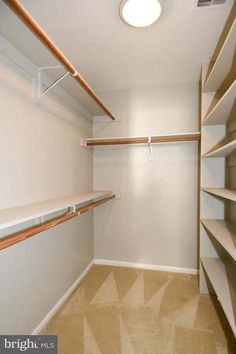 an empty walk in closet with shelves and lights