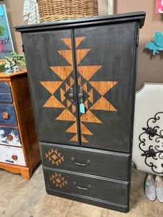 an armoire painted black and orange with geometric designs