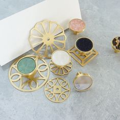 a collection of rings and other items on a table next to a blank paper sheet