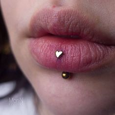 a woman's lips with a tiny heart on the tip of her lip and nose piercing