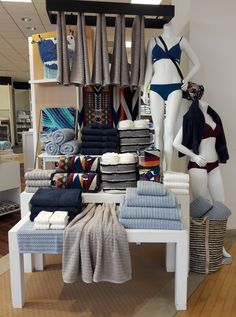 a store display with towels and bathing suits on mannequins in the background