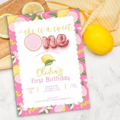 a pink and yellow first birthday party with lemons on the table next to it