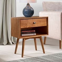 a small wooden table with a lamp on top