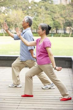 two people doing yoga on a wooden deck