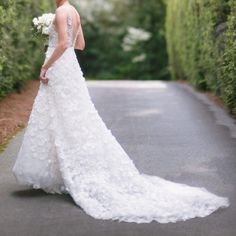 a woman in a wedding dress is standing on the road