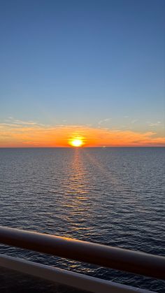 the sun is setting over the ocean as seen from a ferry boat on the water