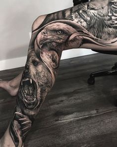 a man's leg with an eagle and bear tattoo on it