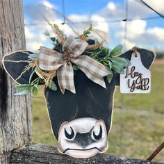 a cow head hanging on a fence post with a tag attached to it's ear