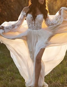 a woman in a white dress is walking through the grass