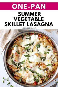 a skillet filled with pasta, cheese and spinach on top of a table