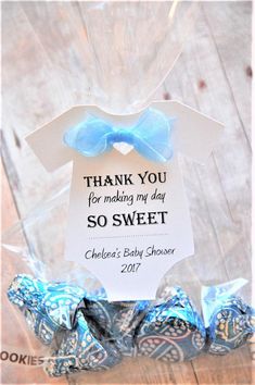 a blue and white baby shower gift in a plastic bag with the words thank you for making my day so sweet