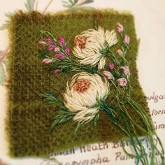 an embroidered piece of cloth with flowers on it