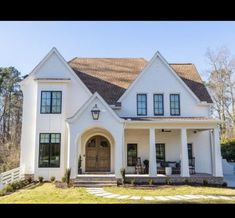 a large white house with lots of windows on it's front door and porch