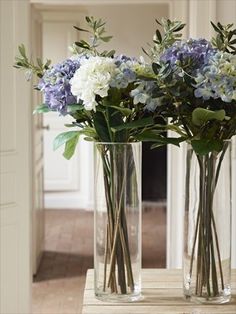 two vases filled with blue and white flowers