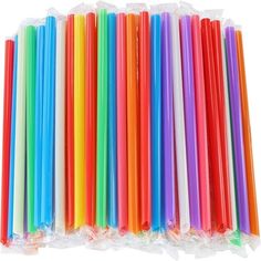 many different colored straws are lined up in plastic bags on a white background photo